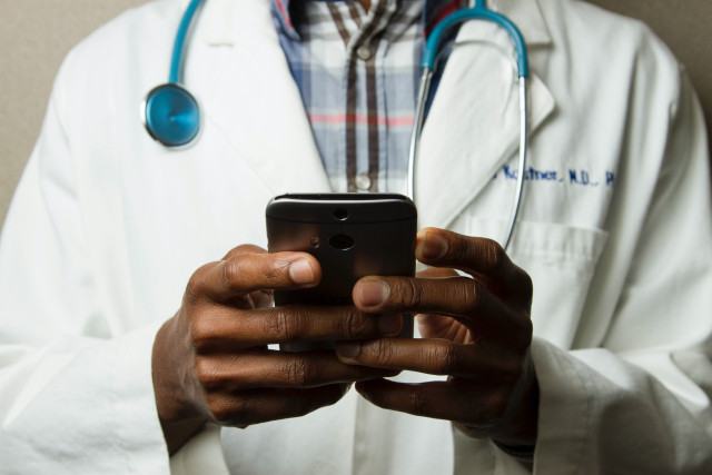 Doctor typing on mobile