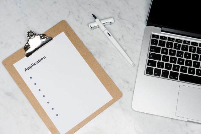 Clipboard and laptop on a table